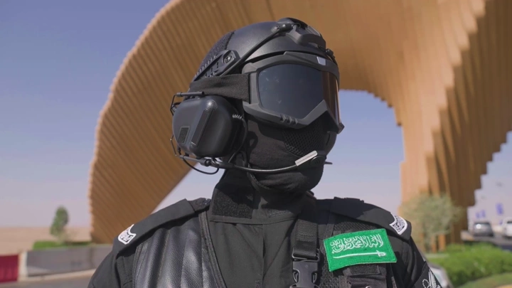 جندي بزي عسكري أمام هيكل خشبي في النهار، لقطة قريبة.