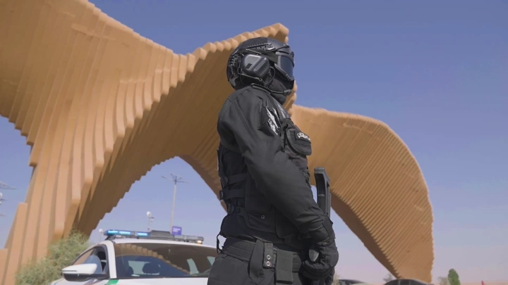 جندي بزي أسود أمام هيكل معماري، لقطة منخفضة.