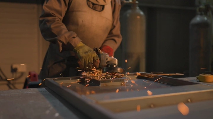 عامل يستخدم آلة طحن في مصنع، لقطة مقربة.