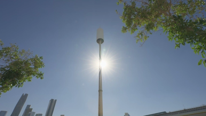 برج اتصالات في مدينة مشمسة، لقطة من الأسفل.