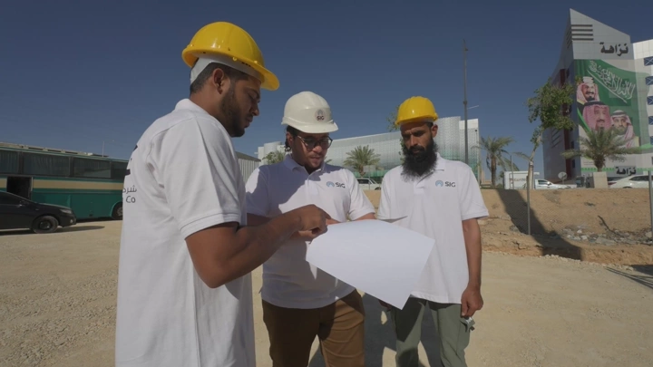 مهندسون في موقع بناء تحت أشعة الشمس، لقطة في النهار.