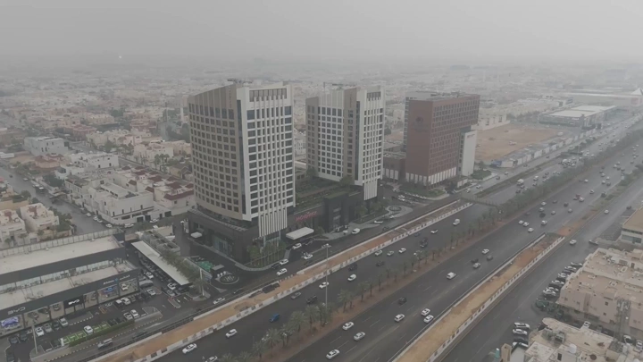 فندق موفنبيك على طريق مزدحم في مدينة كبيرة، لقطة جوية.