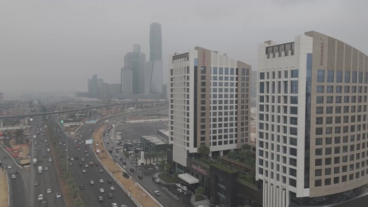 فنادق شاهقة في مدينة مزدحمة تحت سماء غائمة، لقطة جوية.