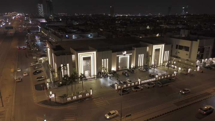 قاعة مضاءة في الليل بمدينة مزدحمة، لقطة جوية.