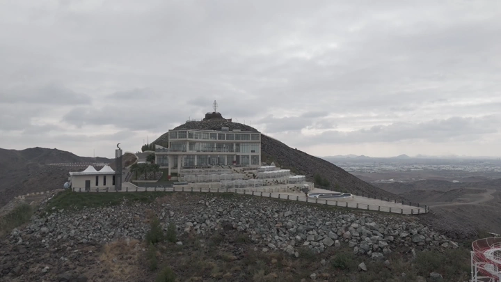 مبنى على قمة جبل تحت سماء غائمة، لقطة جوية.