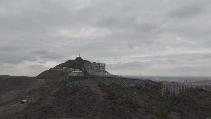 مبنى على قمة جبل تحت سماء غائمة، لقطة جوية.