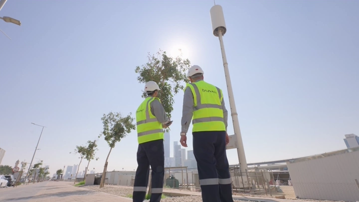 مهندسان يرتديان سترات صفراء في موقع بناء نهاري، لقطة من الخلف.