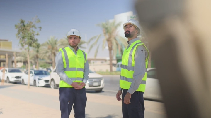 Engineers wearing reflective vests at a construction site during the day, outdoor shot.