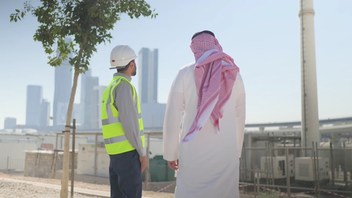 Engineers at a construction site in a modern city, rear view shot.