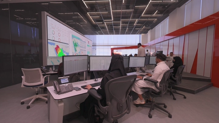 موظفون يعملون في مكتب حديث مع شاشات كبيرة، لقطة داخلية.