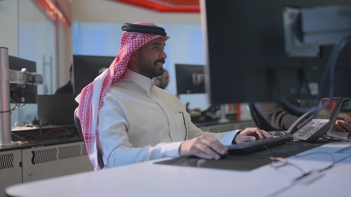 موظف في مكتب حديث يعمل على الكمبيوتر، لقطة داخلية.