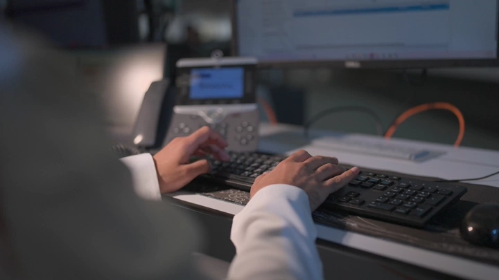 Employee working on computer in modern office, close-up shot.