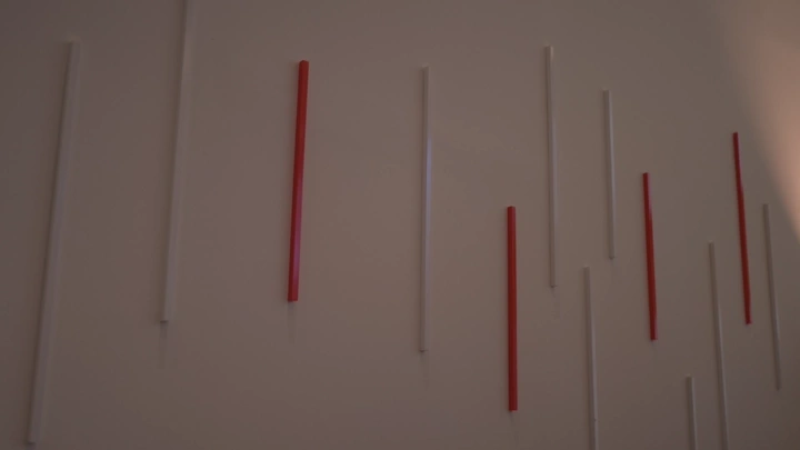 Wall decorated with red and white sticks, indoor shot.