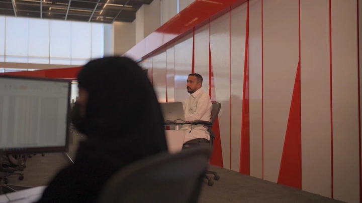 موظفون يعملون في مكتب حديث مع جدران زجاجية، لقطة داخلية.