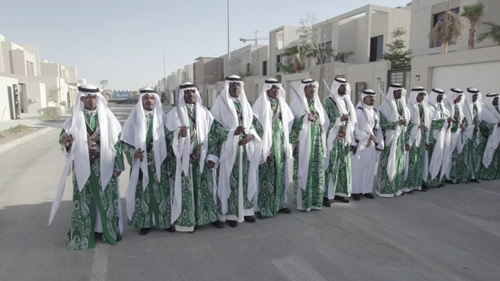 مجموعة رجال يرتدون ملابس تقليدية في شارع حديث، لقطة نهارية.