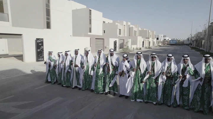 مجموعة رجال يرتدون الزي التقليدي في شارع حديث، لقطة جوية.