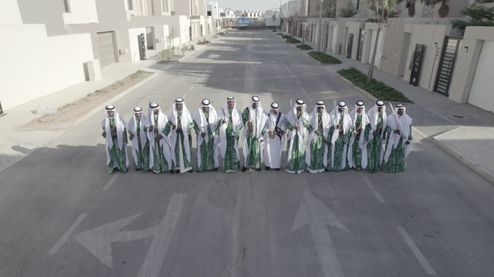 مجموعة رجال يرتدون زي تقليدي في شارع سكني، لقطة جوية.