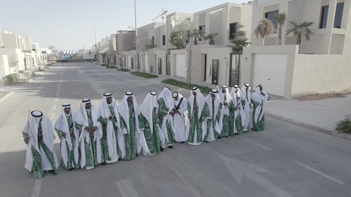 مجموعة رجال في زي تقليدي يحتفلون في شارع سكني، لقطة جوية.