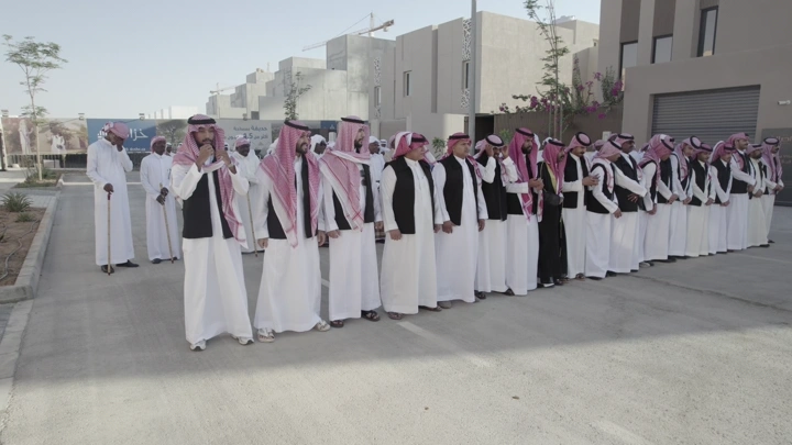 مجموعة رجال يرتدون الزي التقليدي في احتفال خارجي، لقطة نهارية.