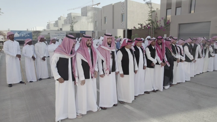 مجموعة رجال يرتدون الزي التقليدي في احتفال خارجي، لقطة نهارية.