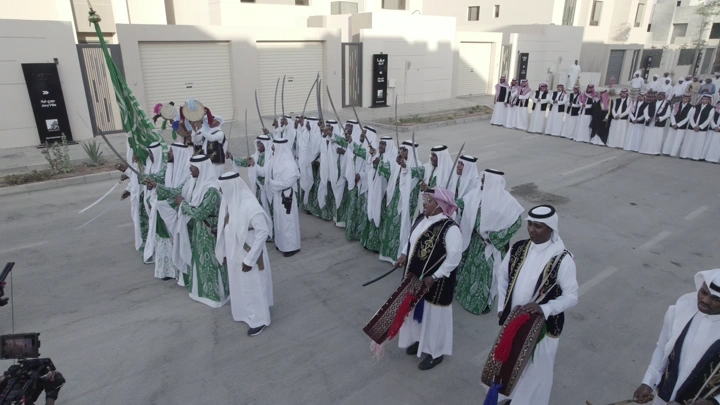 مجموعة رجال في زي تقليدي يحتفلون في الشارع، لقطة جوية.