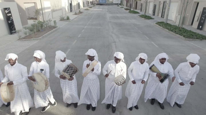 مجموعة رجال يعزفون على الطبول في شارع فارغ، لقطة جوية.