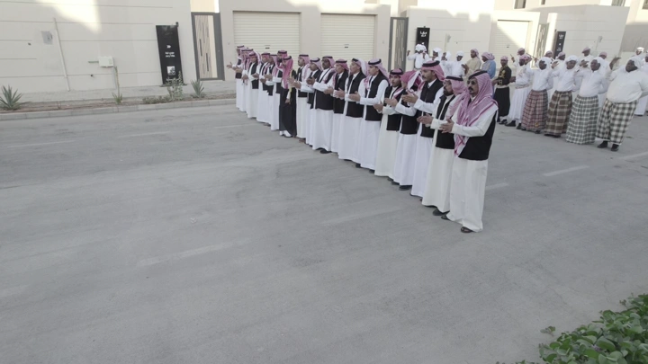 مجموعة رجال في ملابس تقليدية يحتفلون في الشارع، لقطة نهارية.