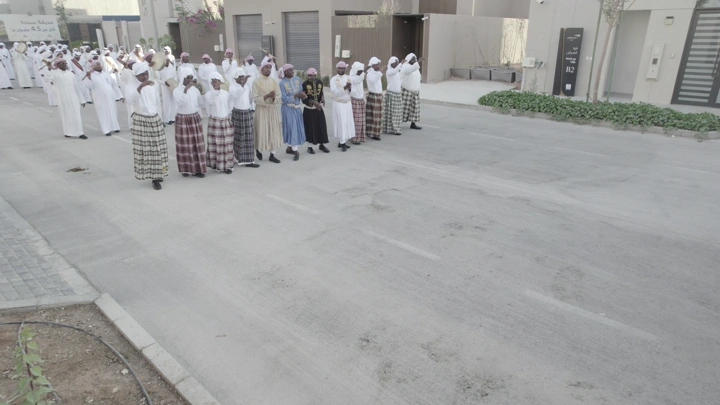 مجموعة من الرجال يرتدون ملابس تقليدية في احتفال بالشارع، لقطة من الأعلى.