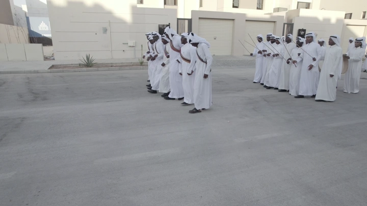 مجموعة رجال يرتدون الزي التقليدي في احتفال خارجي، لقطة نهارية.