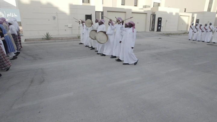 فرقة موسيقية تقليدية في احتفال خارجي، لقطة نهارية.