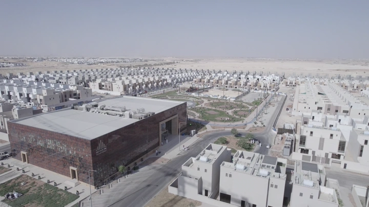 مجمع سكني حديث في منطقة صحراوية، لقطة جوية.