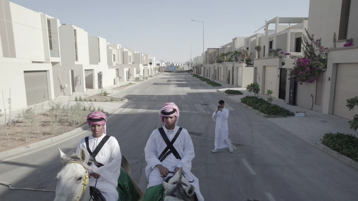 فرسان يرتدون الزي التقليدي في شارع سكني، لقطة نهارية.