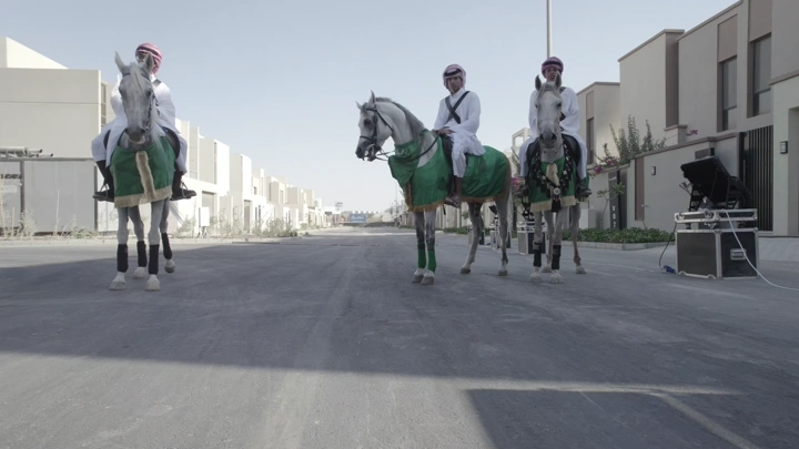 فرسان يرتدون الزي التقليدي في شارع حديث، لقطة نهارية.