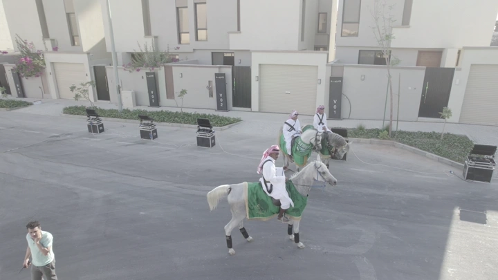 فرسان على خيول بيضاء في حي سكني، لقطة جوية.