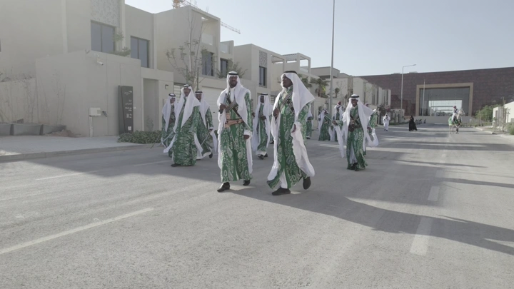 رجال يرتدون الزي التقليدي يسيرون في شارع، لقطة نهارية.