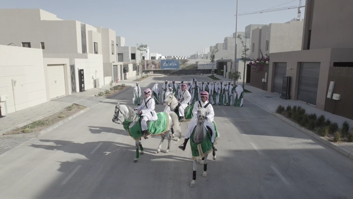 فرسان على خيول في شارع حديث خلال احتفال، لقطة جوية.