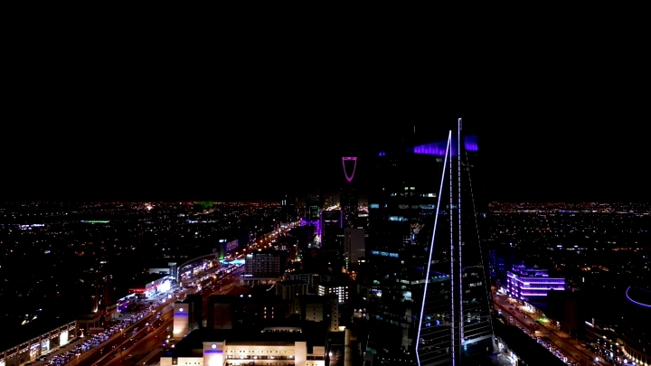 أفق الرياض ليلاً مع برج المملكة مضاء، لقطة جوية.