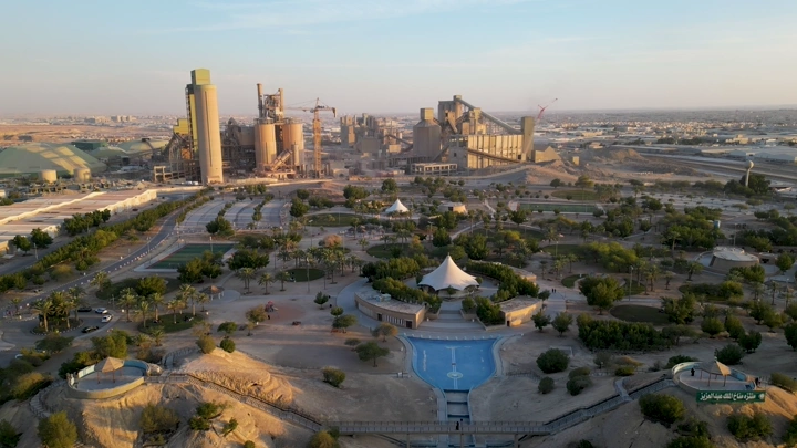 منتزه مناخ الملك عبدالعزيز مع مصنع إسمنت في الخلفية، لقطة جوية.