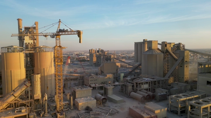 مصنع إسمنت في الأفق مع رافعات، لقطة جوية.