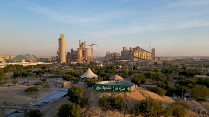 منتزه مناخ الملك عبدالعزيز مع مصنع إسمنت في الخلفية، لقطة جوية.