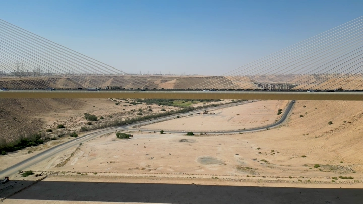 الجسر المعلق في الرياض فوق وادي صحراوي، لقطة جوية.