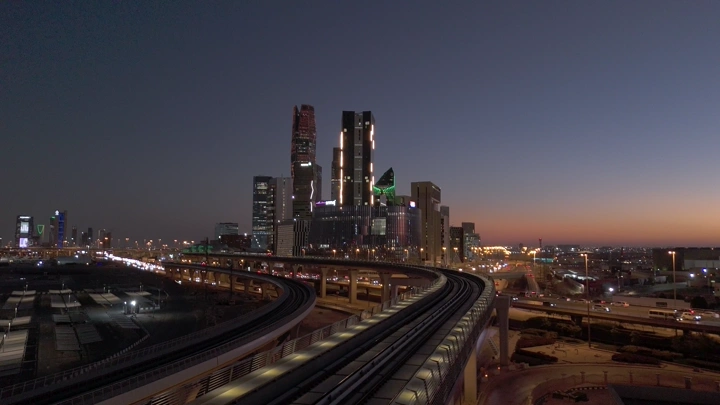 مترو الرياض مع أفق المدينة المالية عند الغروب، لقطة جوية.