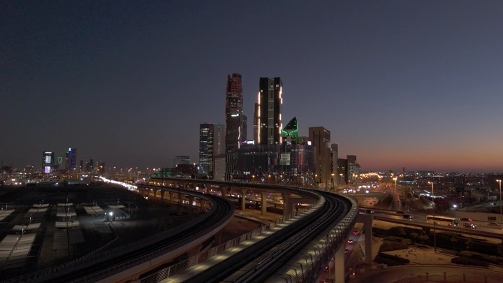 مشهد لمترو الرياض والمدينة المالية عند الغروب، لقطة جوية.