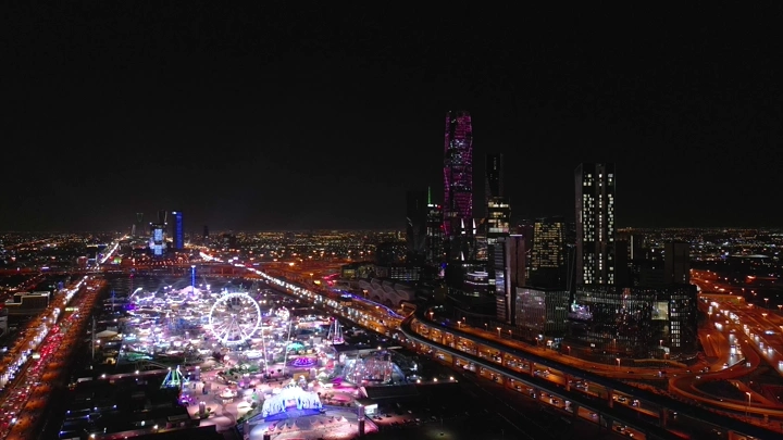 مدينة ملاهي مضاءة في الليل بالرياض، لقطة جوية.