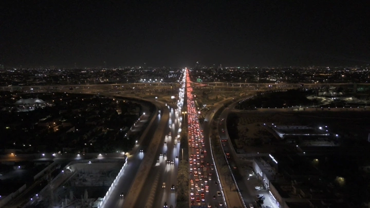 شبكة طرق مزدحمة في الرياض ليلاً، لقطة جوية.