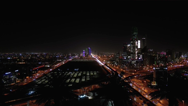 أبراج الرياض ليلًا بإضاءة المدينة، منظر جوي.