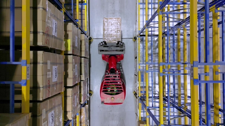رافعة شوكية في ممر مستودع، لقطة من الأعلى.