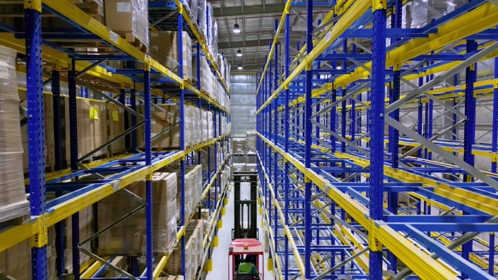 مستودع تخزين مع رفوف مرتفعة ورافعة شوكية، لقطة داخلية.
