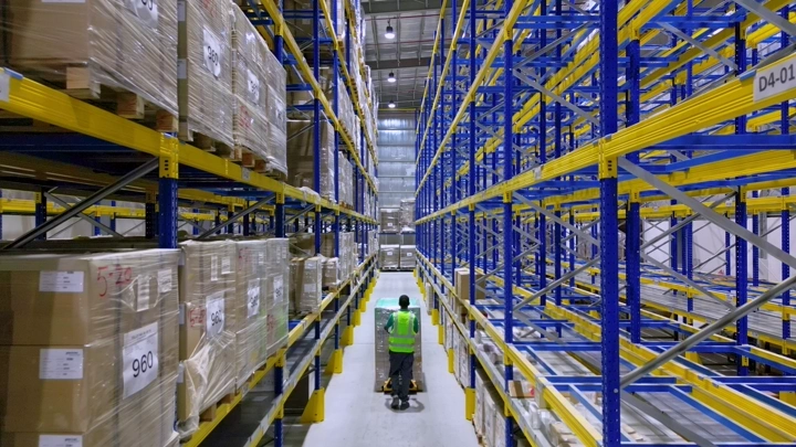 عامل في مستودع تخزين حديث، لقطة من الداخل.