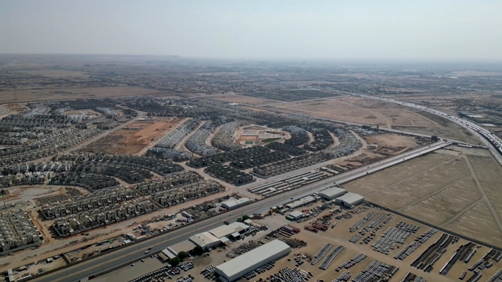 منظر جوي لمنطقة صناعية ومخازن سيارات في يوم مشمس.